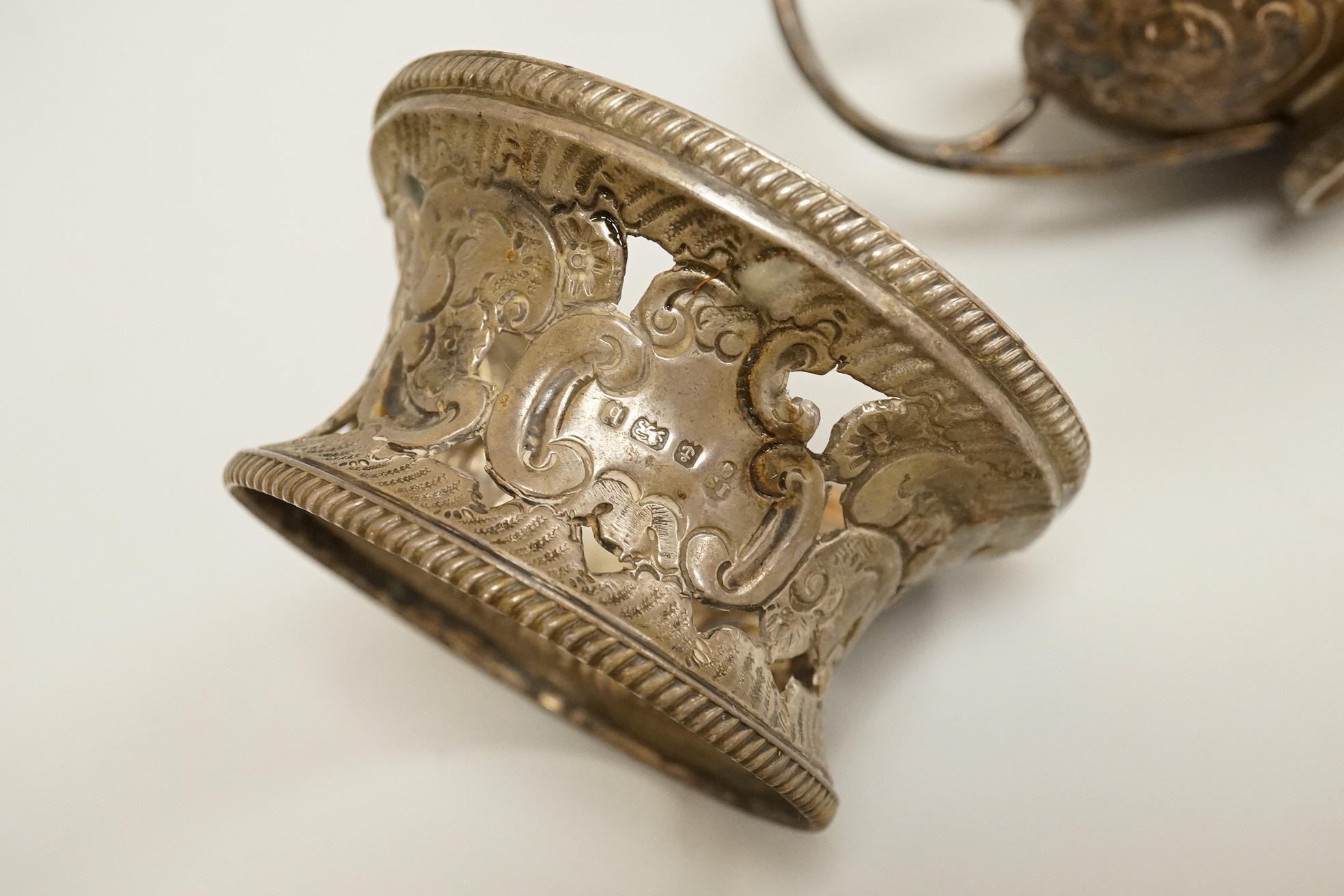 A late George III Irish embossed silver sauce boat, with flying scroll handle, maker. ?S, Dublin, 1817, length 14cm, together with a small Edwardian silver dish ring, I S Greenberg & Co, Birmingham, 1901, 7.2oz.